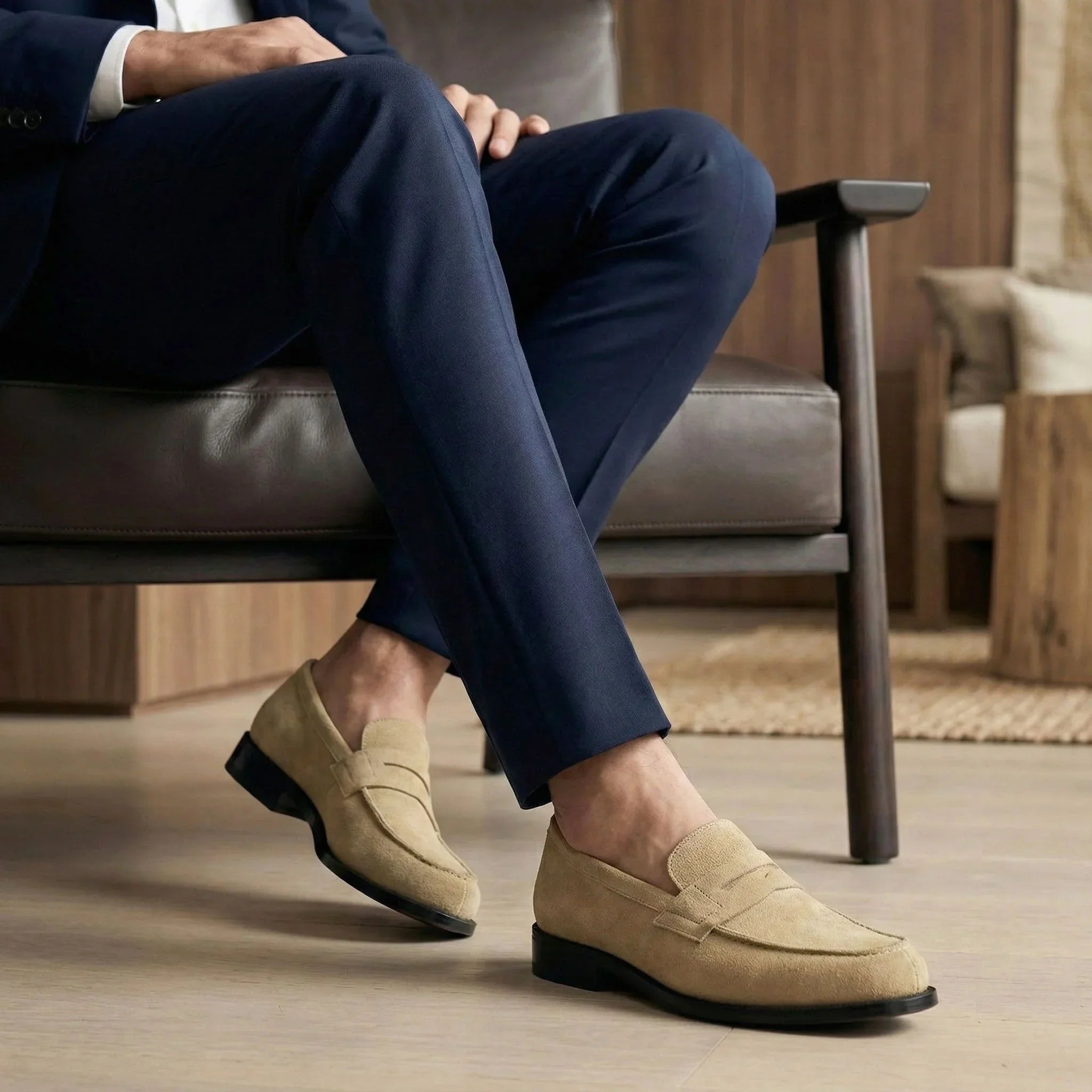 Beige suede loafers with a classic moccasin design and black rubber soles.