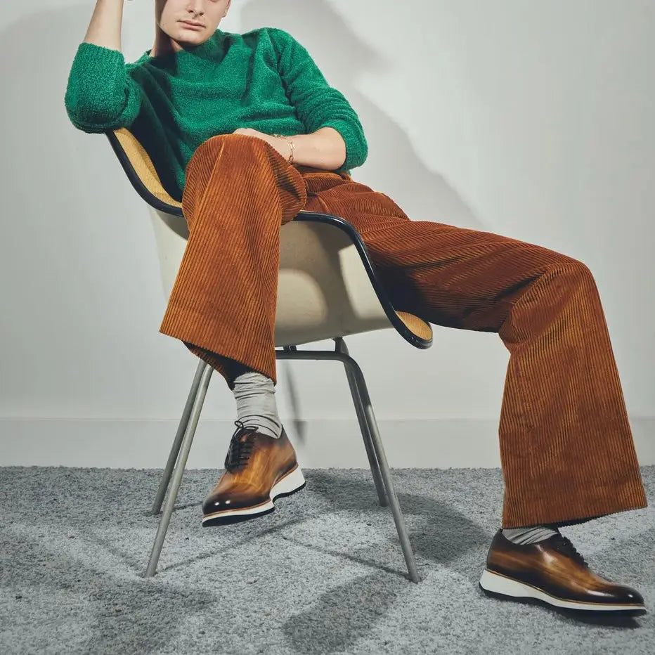 Person in green sweater and brown corduroy pants.