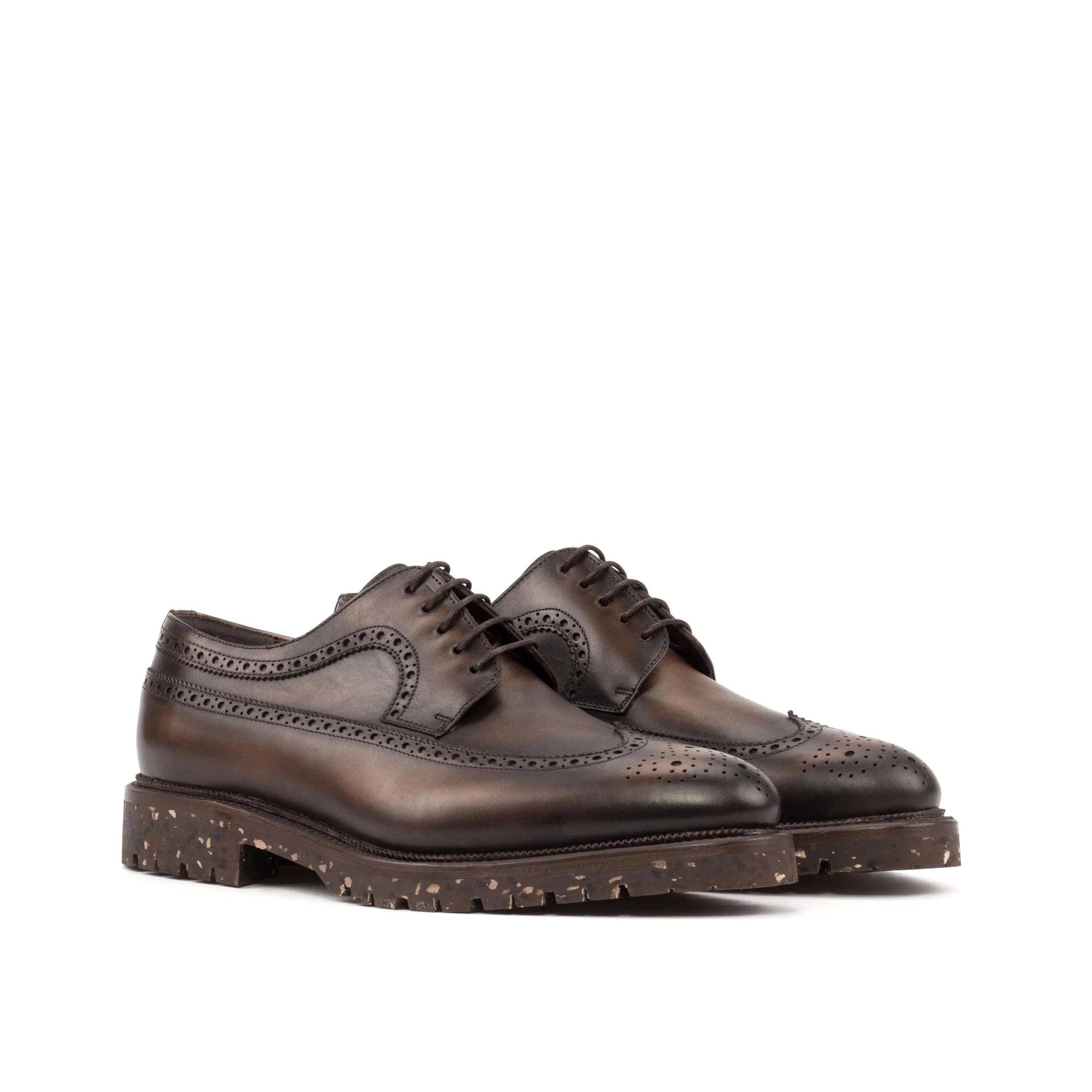 Brown leather brogue oxford shoes with a textured, speckled rubber sole.